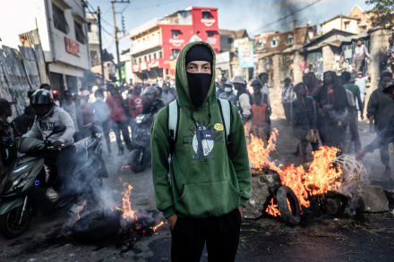 En studerende står foran en brændende barrikade og observerer politibetjente under et sammenstød i Madagaskars hovedstad Antananarivo den 6. oktober 2025.