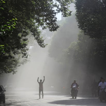 En mand går gennem røgen fra et israelsk angreb i centrum af Teheran.