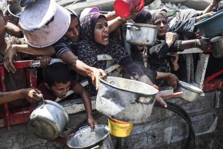 Palæstinensere får udleveret mad i Gaza By.