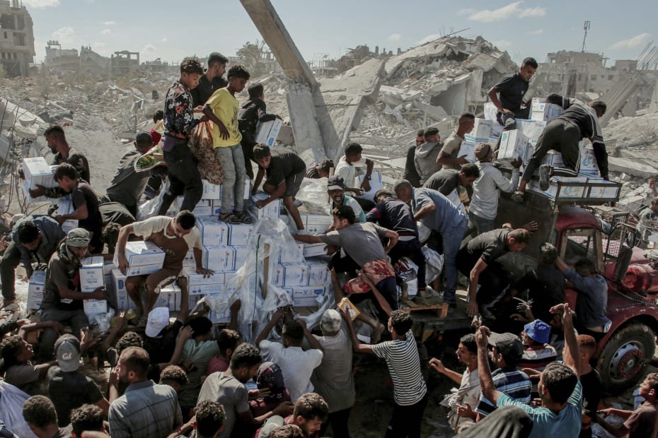 Beboere i Gaza skynder sig at få fat i forsyninger, da en vogn med nødhjælp når frem til Khan Younis i det sydlige Gazastriben den 12. oktober 2025.